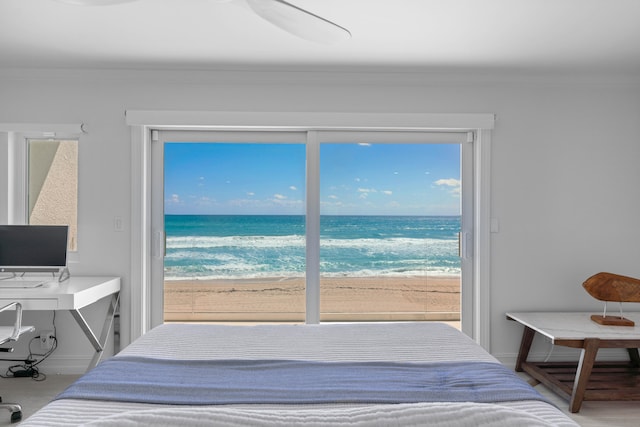 bedroom featuring a water view and a beach view