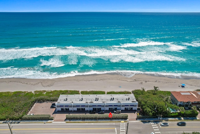 drone / aerial view with a water view and a beach view