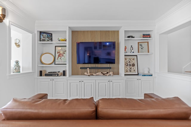 living room featuring crown molding and built in features