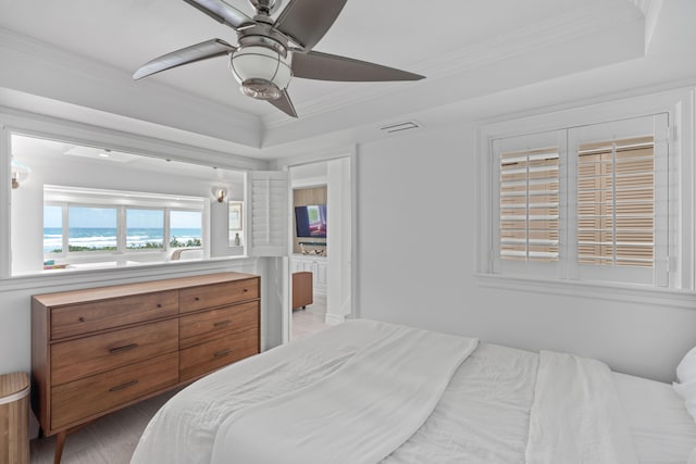 bedroom featuring crown molding, a tray ceiling, and ceiling fan