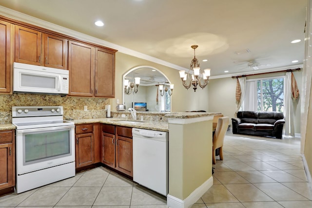 kitchen with ornamental molding, kitchen peninsula, ceiling fan with notable chandelier, and white appliances