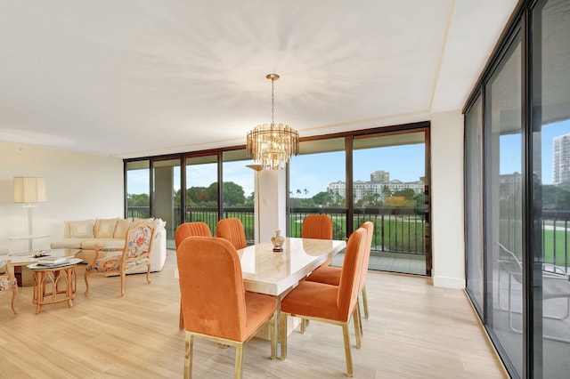 dining area with an inviting chandelier, light wood-type flooring, and floor to ceiling windows