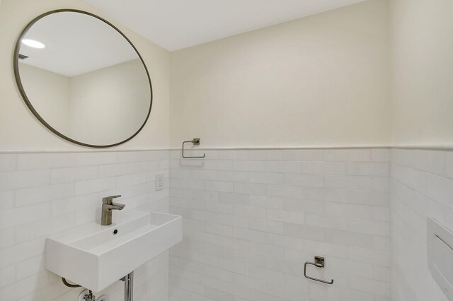 bathroom with sink and tile walls