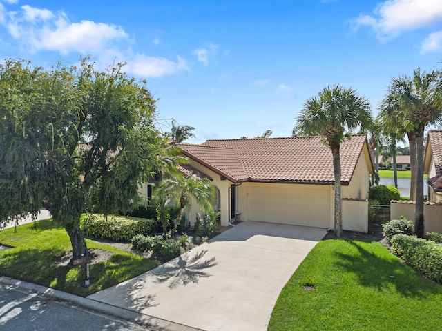 view of front of house with a garage, a front lawn, and a water view