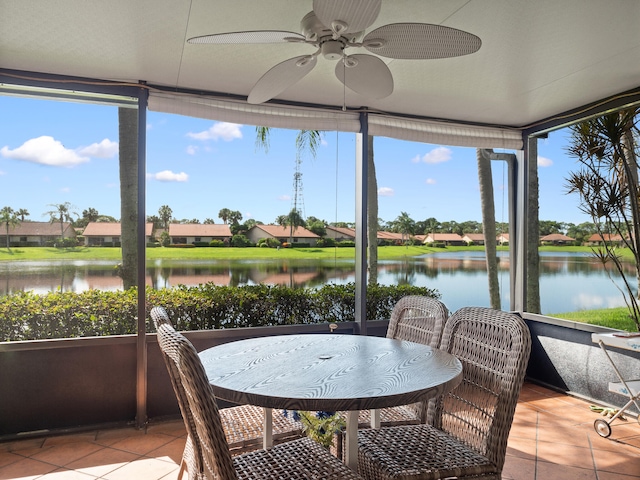 sunroom / solarium featuring a water view and ceiling fan