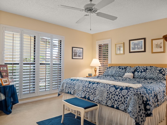 carpeted bedroom with a textured ceiling and ceiling fan