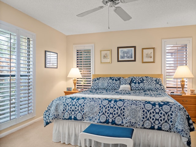 bedroom featuring carpet, ceiling fan, and a textured ceiling