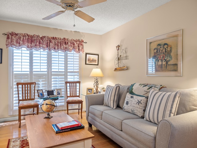 living room featuring a textured ceiling, light hardwood / wood-style floors, and ceiling fan