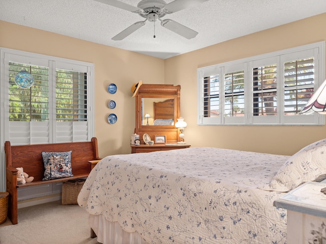 bedroom featuring a textured ceiling, carpet flooring, and ceiling fan