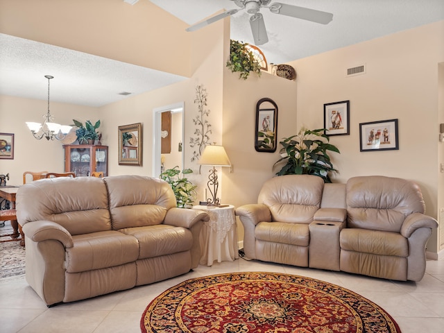 living room with a textured ceiling, light tile patterned flooring, and ceiling fan with notable chandelier