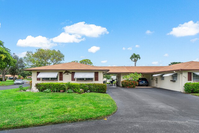 single story home featuring a carport and a front lawn