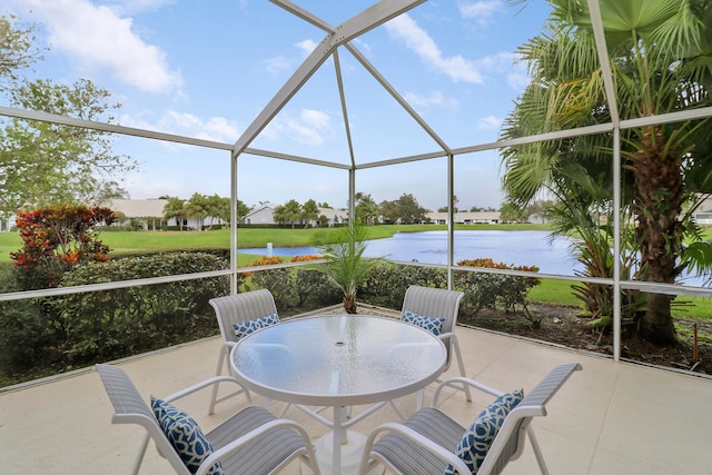 view of patio with a water view and a lanai