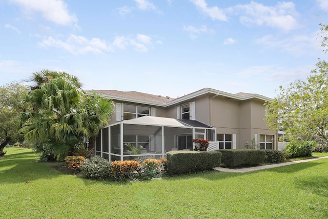 back of property with a sunroom and a lawn