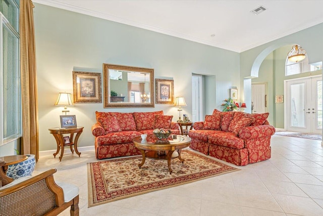 living room with french doors, ornamental molding, and light tile patterned flooring