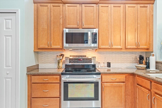 kitchen with tasteful backsplash, stainless steel appliances, and light stone counters