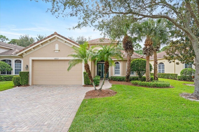 mediterranean / spanish house with a front yard and a garage