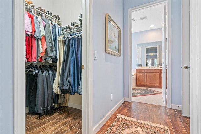 spacious closet with dark wood-type flooring