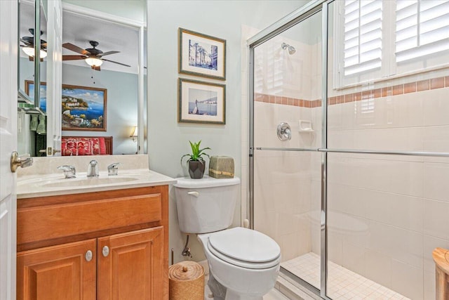 bathroom featuring vanity, an enclosed shower, toilet, and ceiling fan