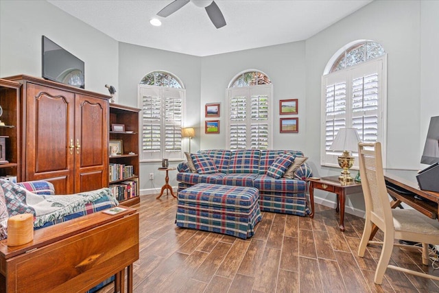 living room featuring dark wood-type flooring and ceiling fan