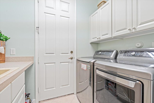 laundry room featuring independent washer and dryer, cabinets, and light tile patterned floors