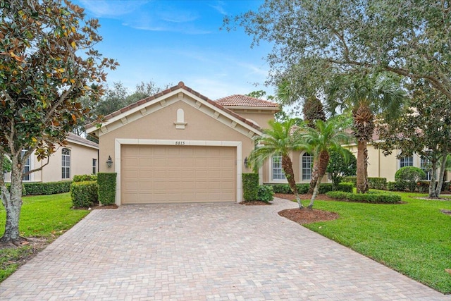 mediterranean / spanish house with a garage and a front lawn