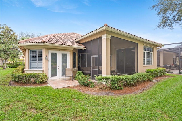 back of house featuring a lanai, a yard, and a sunroom