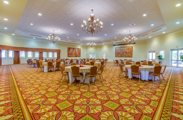 dining space featuring french doors, ornamental molding, a high ceiling, and a raised ceiling