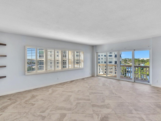 empty room with a wealth of natural light and a textured ceiling