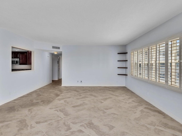 unfurnished room featuring a textured ceiling