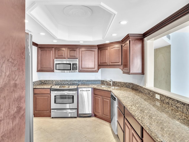 kitchen with sink, stone countertops, stainless steel appliances, and a raised ceiling