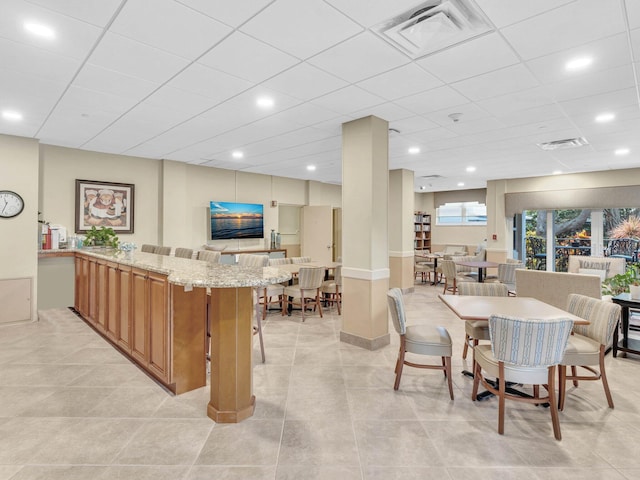 tiled dining room featuring a drop ceiling