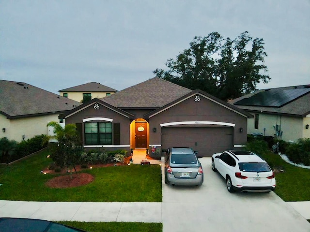 ranch-style house featuring a front yard and a garage