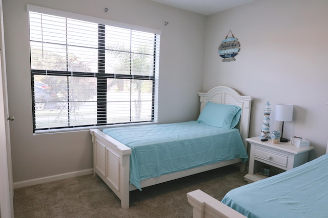 bedroom with dark colored carpet and multiple windows