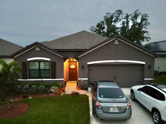 single story home featuring a garage and a front lawn