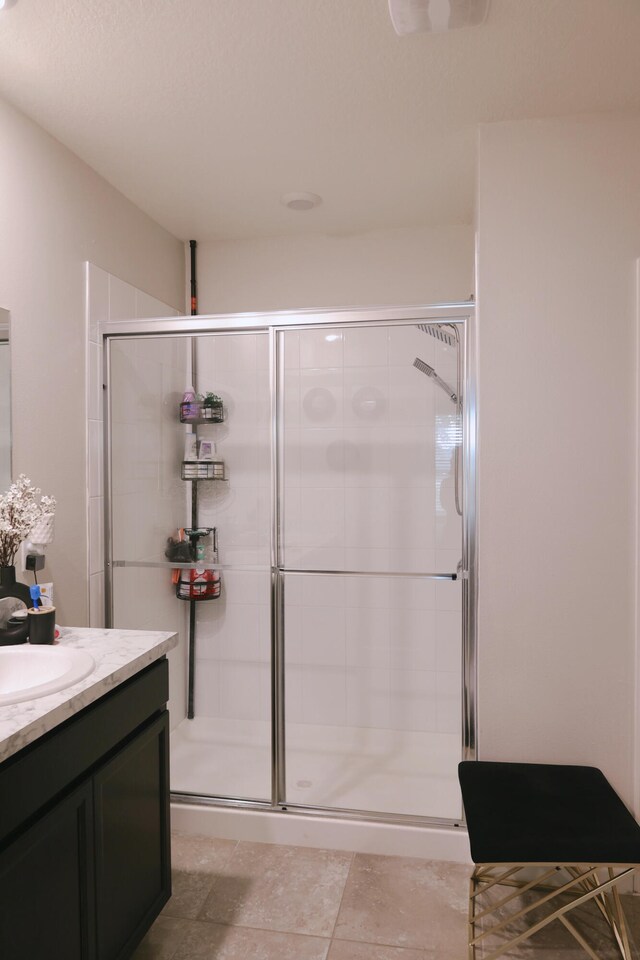 bathroom featuring vanity, tile patterned floors, and walk in shower