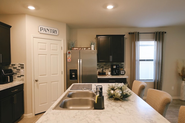 kitchen with sink, stainless steel fridge, and backsplash