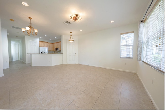 unfurnished living room featuring a notable chandelier and light tile patterned floors