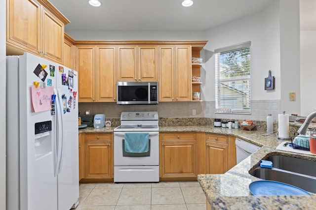 kitchen featuring tasteful backsplash, sink, light tile patterned floors, light stone counters, and white appliances