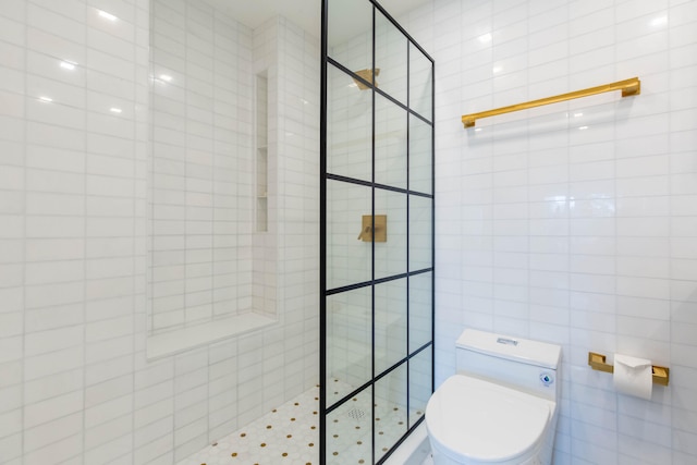 bathroom featuring toilet, tile walls, and tiled shower