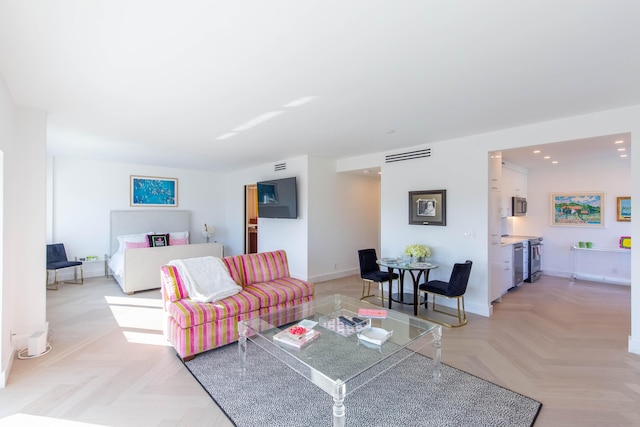 living room featuring baseboards, visible vents, and recessed lighting