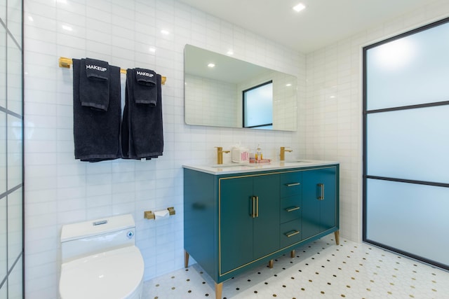 bathroom featuring vanity, toilet, and tile walls