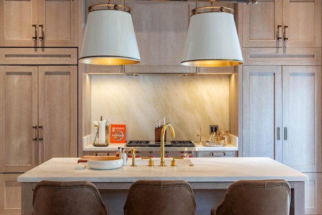 kitchen with wooden counters, paneled refrigerator, light brown cabinetry, a kitchen breakfast bar, and a kitchen island with sink