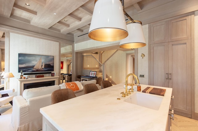 dining space featuring beam ceiling, sink, and light parquet floors