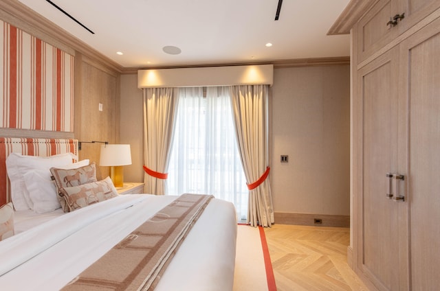 bedroom featuring ornamental molding and light parquet floors