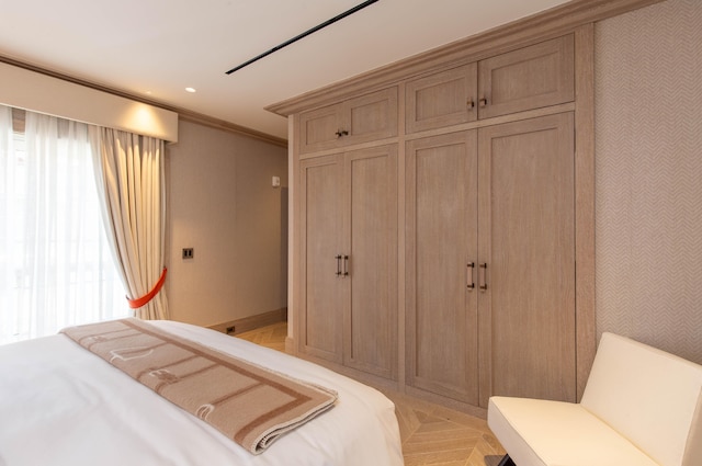 bedroom with light parquet floors and ornamental molding