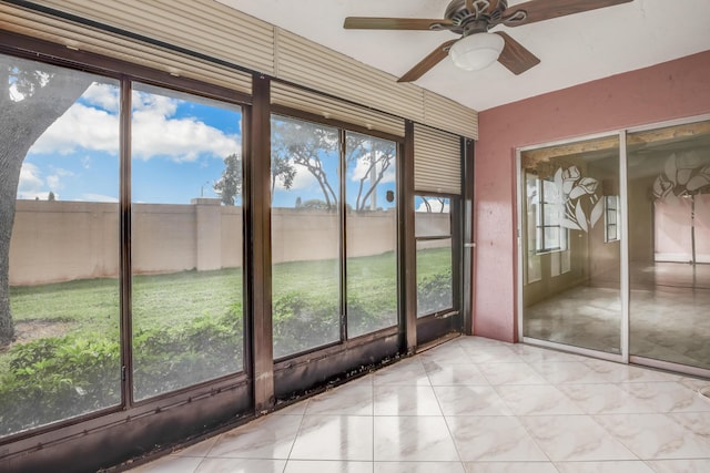 unfurnished sunroom with ceiling fan