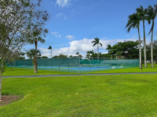 view of tennis court with a yard