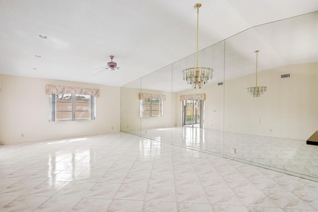 unfurnished room featuring lofted ceiling, a healthy amount of sunlight, and ceiling fan with notable chandelier