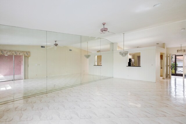 unfurnished room featuring lofted ceiling and ceiling fan with notable chandelier