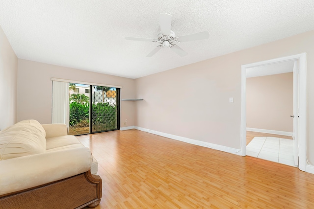 unfurnished living room featuring ceiling fan, a textured ceiling, and light hardwood / wood-style floors